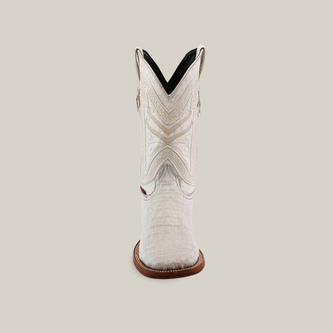 The Exotic Caiman Horn Back - White boot showcases exquisite craftsmanship with intricate stitching on premium Caiman leather. Featuring a square toe, detailed shaft embroidery, and a brown sole, it highlights exceptional quality against its simplistic backdrop.