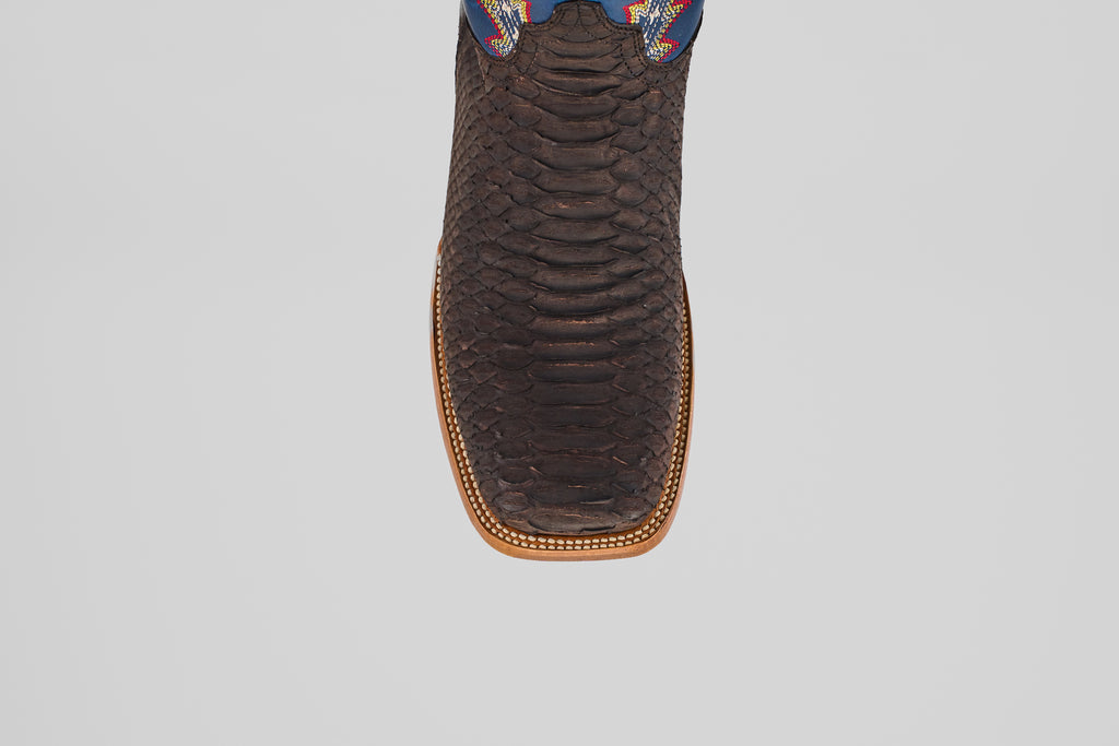 A close-up top view of the Morgan - Matte Brown - Square Toe men’s boot, showing its textured matte brown finish, detailed stitched edge, and a hint of colorful design near the upper.