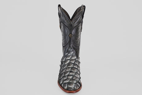 The Conor - Newspaper - Roper Toe boot features black exotic leather with a textured, scaly pirarucu-inspired pattern and intricate shaft stitching, displayed upright on a plain white background.