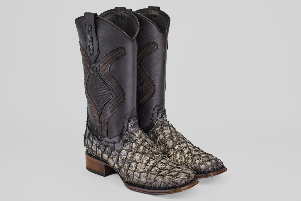 Introducing the Conor Platinum - Newspaper - Square Toe (Diamond): cowboy boots with black leather shafts, textured gray pirarucu leather feet, and brown wooden soles—ideal western boots for men wanting standout style.