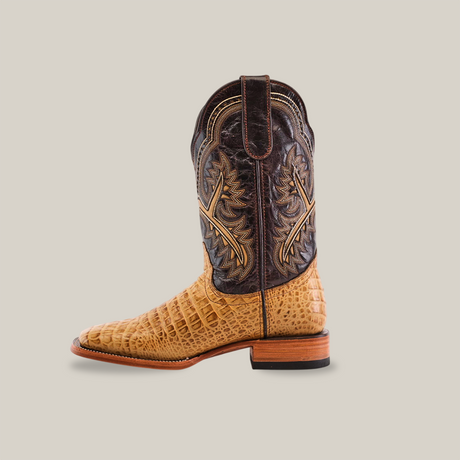 The Caiman Belly Print Orix - Square Toe boot features a side profile view with premium cowhide in a caiman belly print, a darker brown upper adorned with intricate stitching, and a wooden heel, all set against a plain white background.