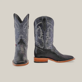 The Lizard Print Black - Square Toe boots showcase intricate white stitching on premium cowhide exteriors. One boot stands upright while the other is angled to highlight the detailing, featuring a leather sole, all elegantly set against a plain white background.