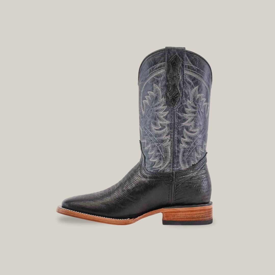 The Lizard Print Black - Square Toe cowboy boot, showcased on a plain white background, is a single black boot with intricate white stitching and a leather sole. Made from premium cowhide, it features a pointed toe, wooden heel, and decorative shaft patterns.