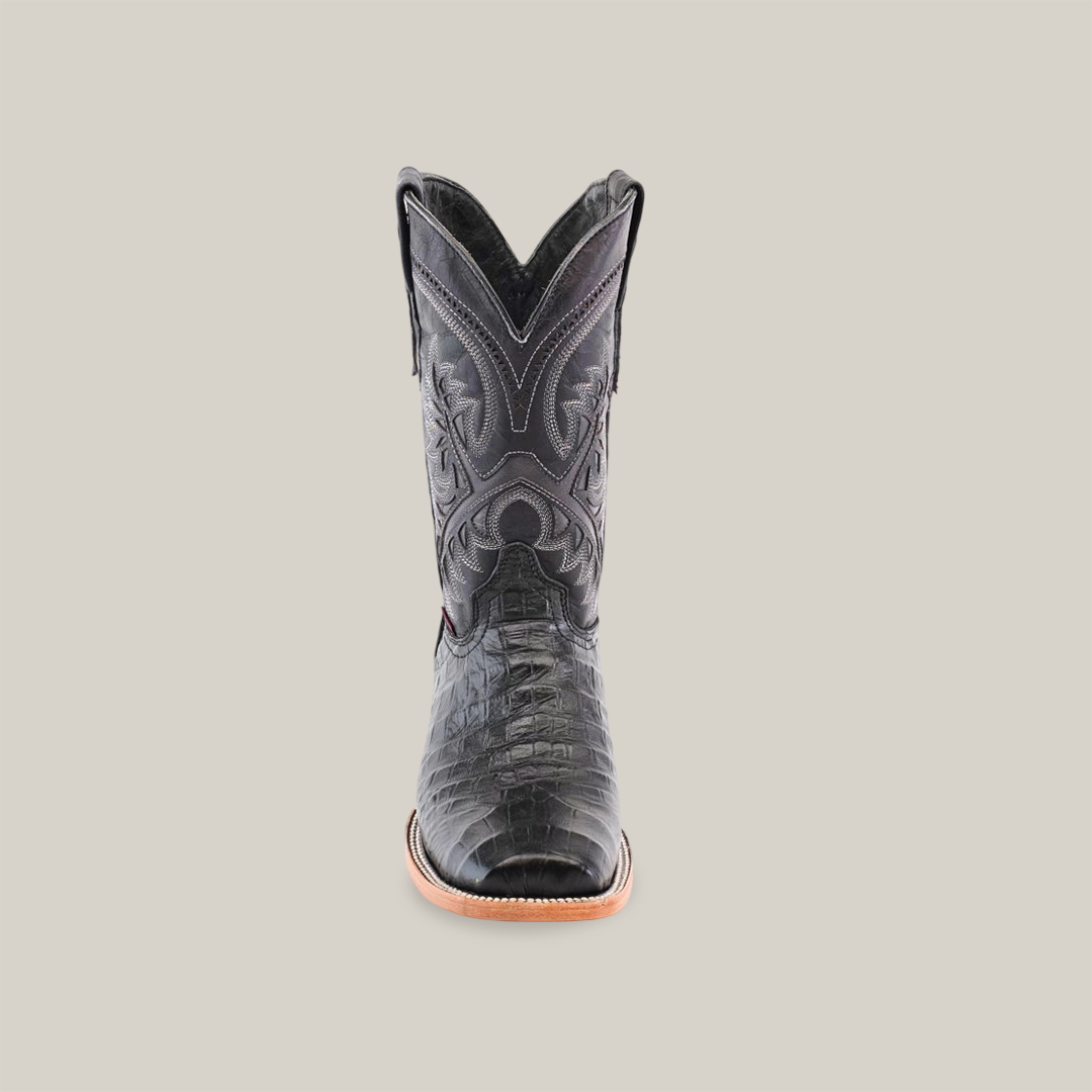 The Caiman Belly Print Black - Square Toe boot, displayed against a plain white background, is crafted from premium cowhide leather. It features intricate shaft stitching, a pointed toe despite the name, and a light brown sole, exuding timeless elegance.