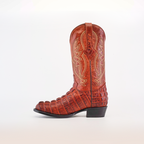 The Crocodile Tail Print Cogñac - Round Toe cowboy boot features reddish-brown cowhide leather with an embossed pattern, premium leather sole, intricate shaft stitching, and a dark heel, all set against a plain white background.