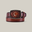 Introducing the Over Chestnut Laser Belt - BC158: a brown premium leather belt with a rectangular laser-engraved buckle featuring a decorative C design. Coiled against a neutral backdrop, it adds sophistication to any ensemble.