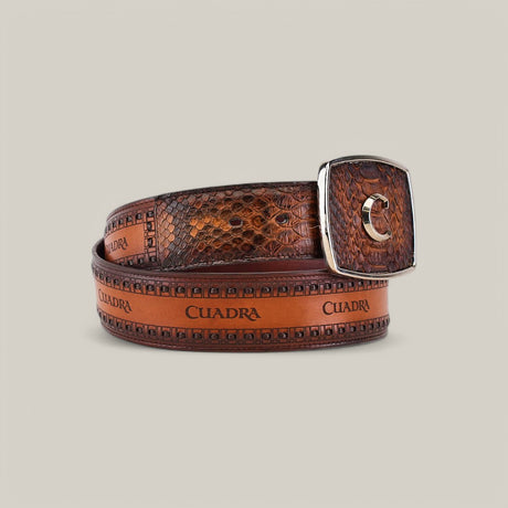 The Brown Python Laser - BC200 is a brown leather belt with a textured snake skin pattern, showcasing quality craftsmanship. It repeatedly displays the Cuadra brand name and features a laser-engraved silver buckle with the letter C, set against a plain light gray background.