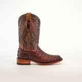 The Exotic Caiman Hornback - Brown - Rodeo Toe boot is crafted with caiman leather, featuring intricate stitching, crocodile texture on a plain background, detailed hornback accents, and a small red label near the sole for unique charm.