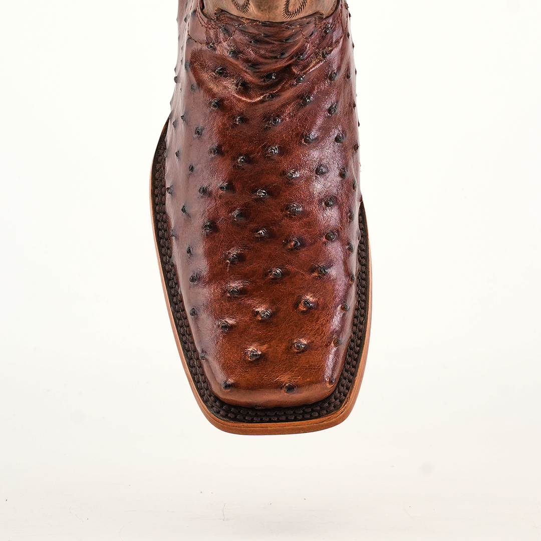 The Exotic Ostrich - Brown - Rodeo Toe shoe features a detailed ostrich skin texture, square toe design, and visible sole stitching that highlights its superior craftsmanship akin to classic cowboy boots.