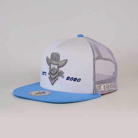 The De Rancho Cap Classic White is a white and light blue trucker cap with a gray embroidered cowboy logo, Est. 2020 on the front, De Rancho on the side, and a breathable mesh back panel.