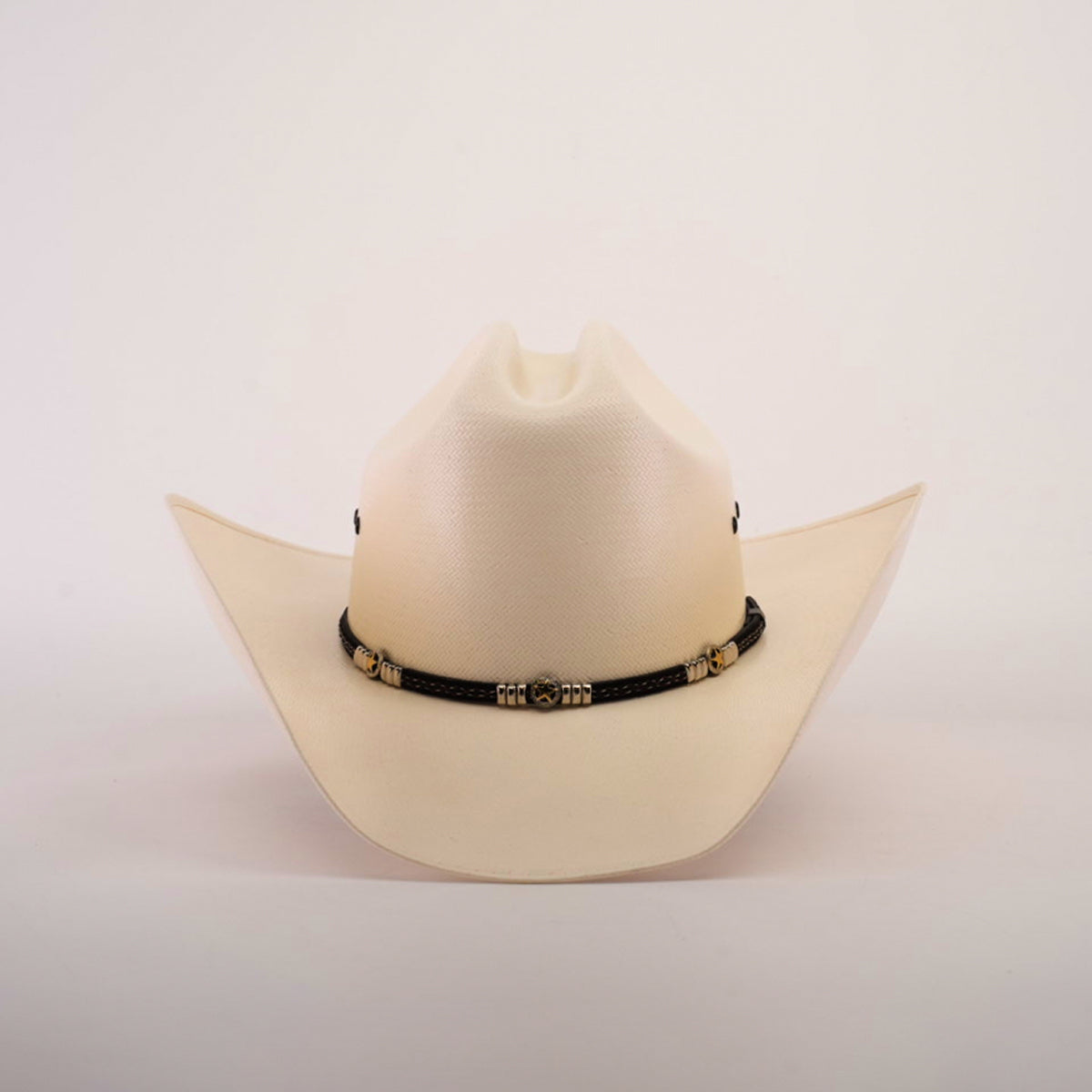 The 500X Country Straw Hat features a plain white design with a wide brim, crafted from premium materials, and adorned with a black band featuring ornate gold accents.