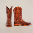 A pair of Handtooled Leave Brown boots in premium cowhide, featuring intricate embossing on a light gray base. One handcrafted boot stands upright, the other is on its side, highlighting the exquisite craftsmanship and rodeo toe design with a slip-resistant sole.