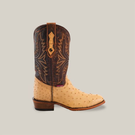 The Exotic Full Quilt Ostrich - Orix - Round Toe features a tan ostrich leather foot and dark brown shaft with intricate stitching, embodying cowboy style. Its striking design is showcased against a plain beige background.