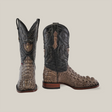 The Exotic American Alligator Head boots in gray are luxury square toe boots featuring embossed leather with a mix of dark and light brown tones. Handcrafted from alligator leather, they showcase detailed stitching and patterns on the shaft and foot, displayed upright against a plain background.