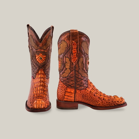 The Exotic American Alligator Head - Cogñac - Square Toe boots are artisan-crafted from textured brown leather, featuring intricate patterns. One boot highlights the side detail, while the other showcases the toe and front pattern against a plain, light background.