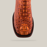 Close-up of an orange handmade artisan boot in Exotic American Alligator leather, Cogñac - Square Toe, showcasing intricate detail and texture with a broad square toe.