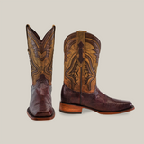 Two Exotic Lizard - Brown - Rodeo Toe cowboy boots are against a plain background. The left boot is angled to show embroidery, while the right shows its detailed brown and tan leather with a wooden heel, reflecting authentic craftsmanship and handcrafted elegance.