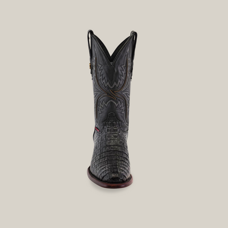 The Exotic Caiman Hornback - Black boot features handcrafted leather with intricate stitching and a textured surface. It has a round toe and pull straps, all displayed on a plain background.