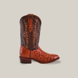 The Exotic Full Quilt Ostrich - Brandy boot highlights luxurious ostrich leather with a brown foot and a darker stitched shaft. This handcrafted design features a stacked heel and round toe, presented against a plain beige backdrop.