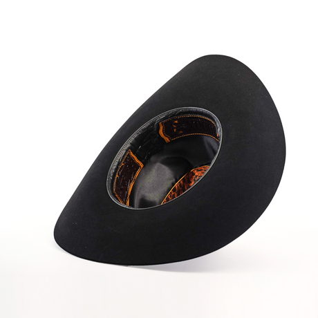 A 1000X Imperial Black by Larry Mahan is showcased with its interior facing up against a white background, revealing a blend of black and brown hues. The western hat features a wide brim and exudes classic style.