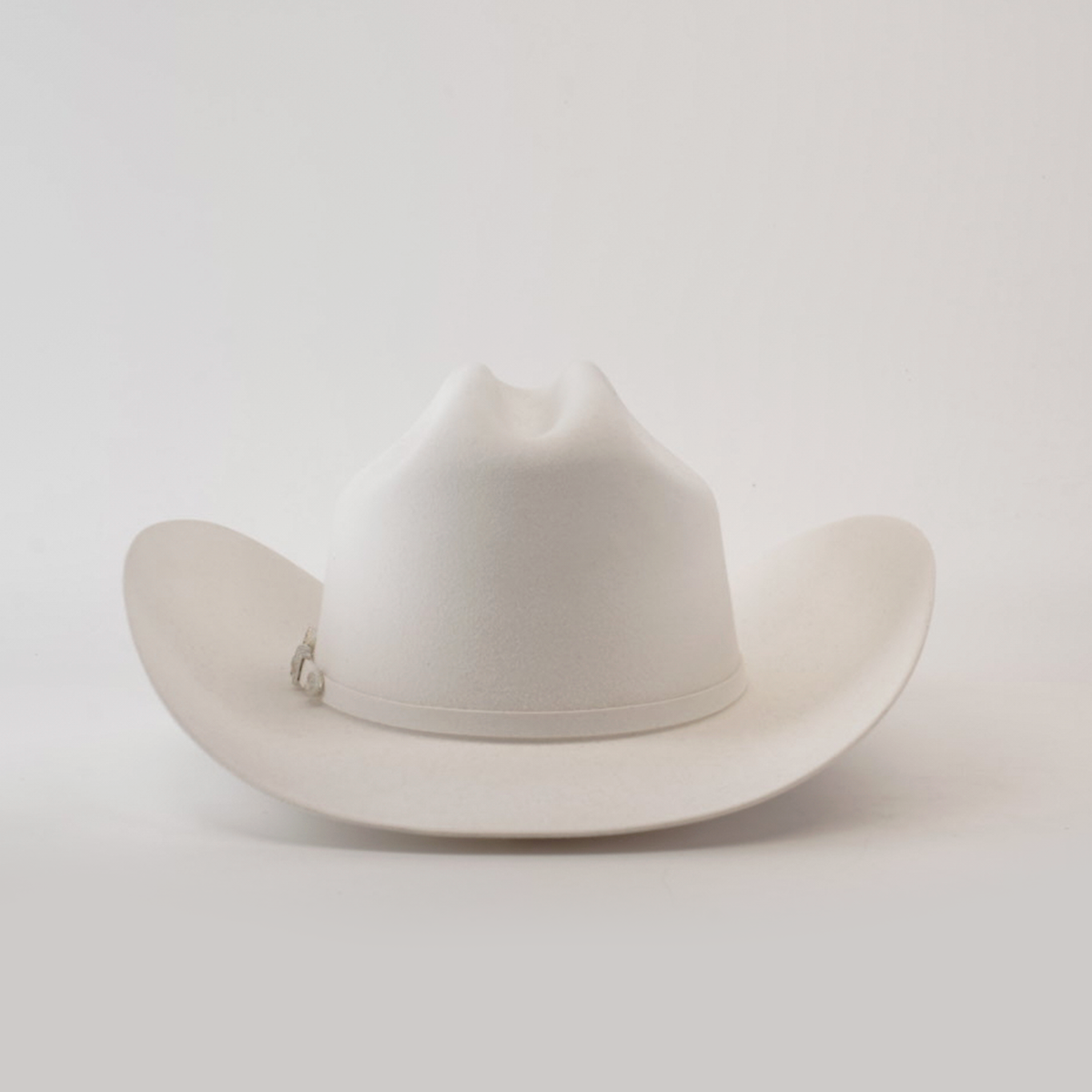 The 6X Real White is a luxurious cowboy hat, skillfully handcrafted by artisans, featuring a wide brim and creased crown set against a plain white background.