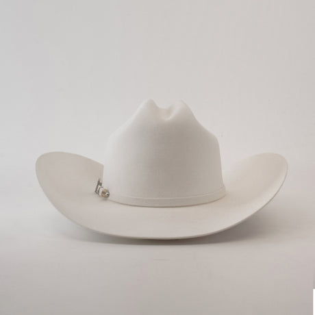 The 100X Independencia White is a luxurious cowboy hat made of full beaver fur, featuring a curved brim and a pin on the band, set against a plain light gray background.