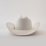 The 500X Superior White is a luxurious belly beaver fur cowboy hat with a slightly curved brim and distinct crown crease. Set on a plain white background, it boasts an elegant decorative band around the base of the crown.