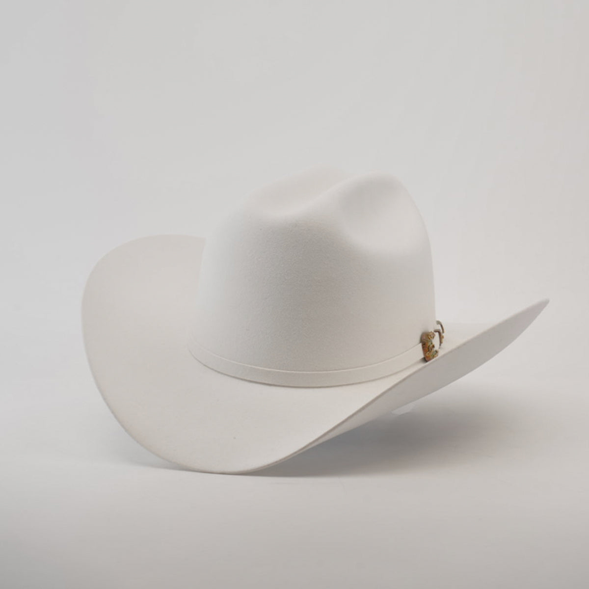 The 1000X Imperial White, a white Western hat with a wide brim and decorative band, exudes classic style and charm against a plain light background.