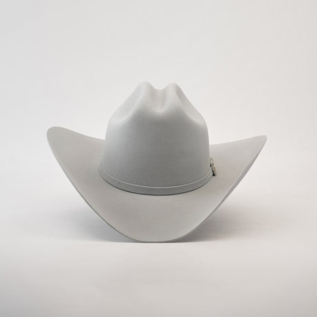 The 10X Jerarca Platinum, a gray fur felt cowboy hat with a wide brim and center crease, exudes classic western style. Its subtle hatband complements the design, reminiscent of Larry Mahans style, and is shown upright against a plain white background.