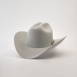 The 500X Superior Platinum is a light gray cowboy hat made from belly beaver fur, featuring a wide brim and an understated decorative band around the crown with a small emblem on the side, all set against a plain white background.