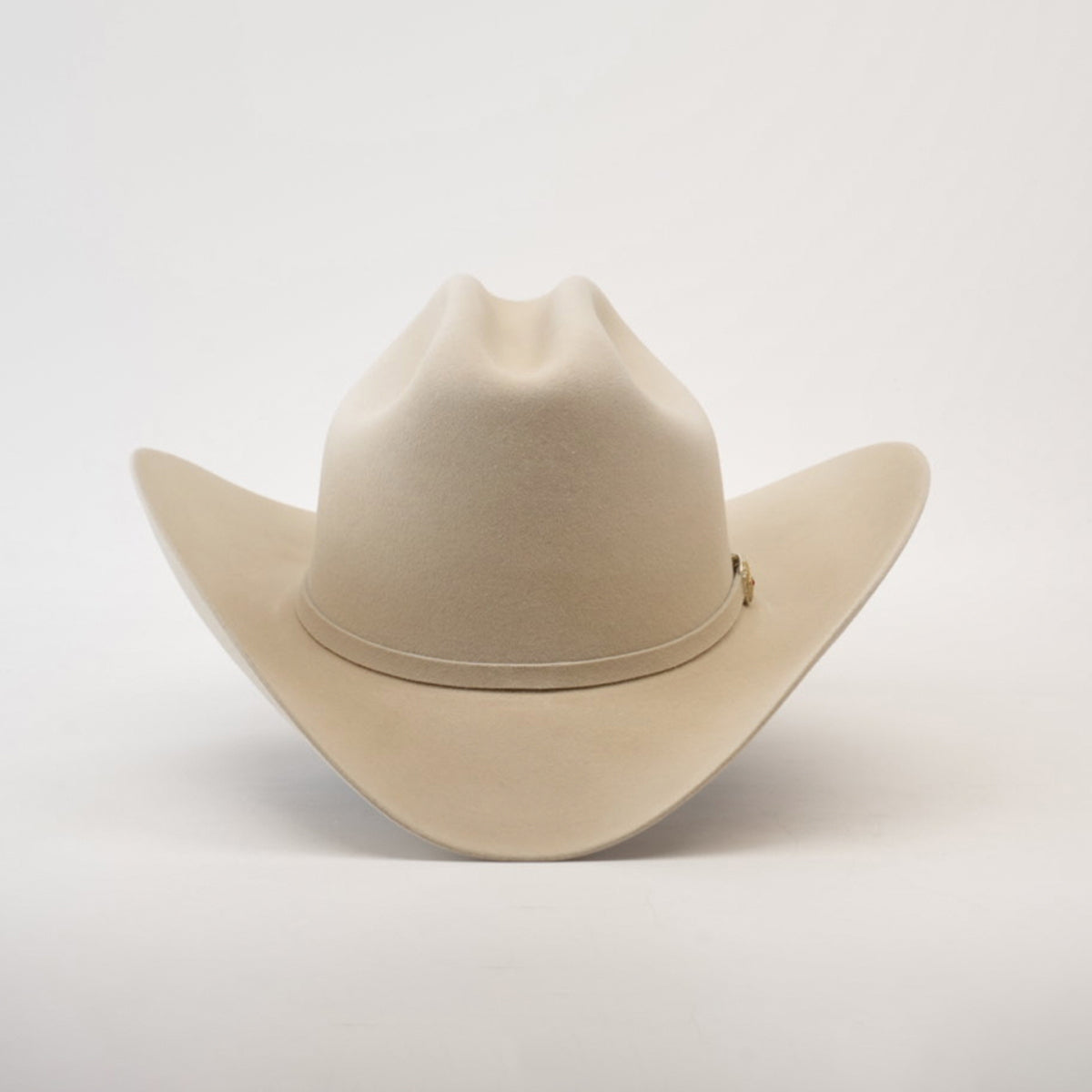 The 6X Real Belly, a premium beige fur cowboy hat, sports a wide brim and pinched crown with subtle decorative stitching, set against a plain white background.