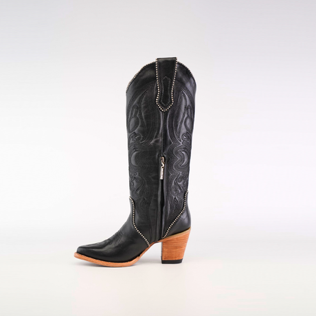 A single Linda Studs Tall Shaft Black - J Toe boot from the Platinum Collection features a wooden block heel and intricate patterns with silver studs, against a plain white background.