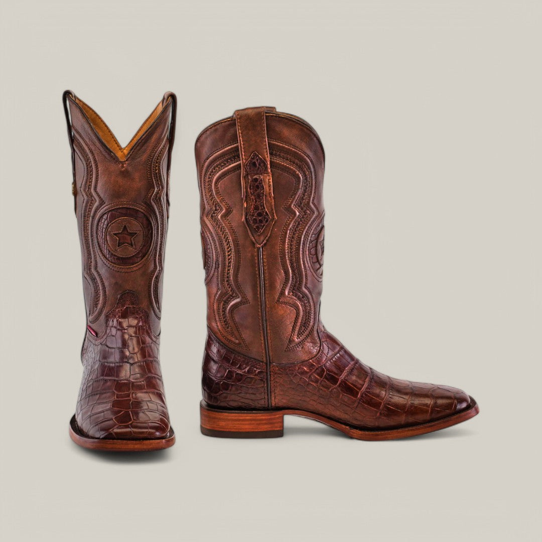 Exotic American Alligator Belly boots in brown feature intricate stitching and a textured pattern, showcasing one forward-facing boot with a star emblem and the other in side profile with detailed leatherwork and a smooth wooden heel.