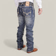 A man showcases Western Blue Straight Fit Embroidered Jeans - W436 with intricate stitching and a bull logo patch, paired with a white button-up shirt and tan leather shoes. Hes captured on a neutral background, facing away from the camera.