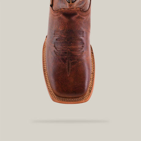 The Fresno Shedron Star - Square Toe boot features a close-up of its brown leather crafted with premium cowhide, intricate upper stitching centered for emphasis, and a lighter tan sole with a stitched border. The backdrop is white for better contrast.