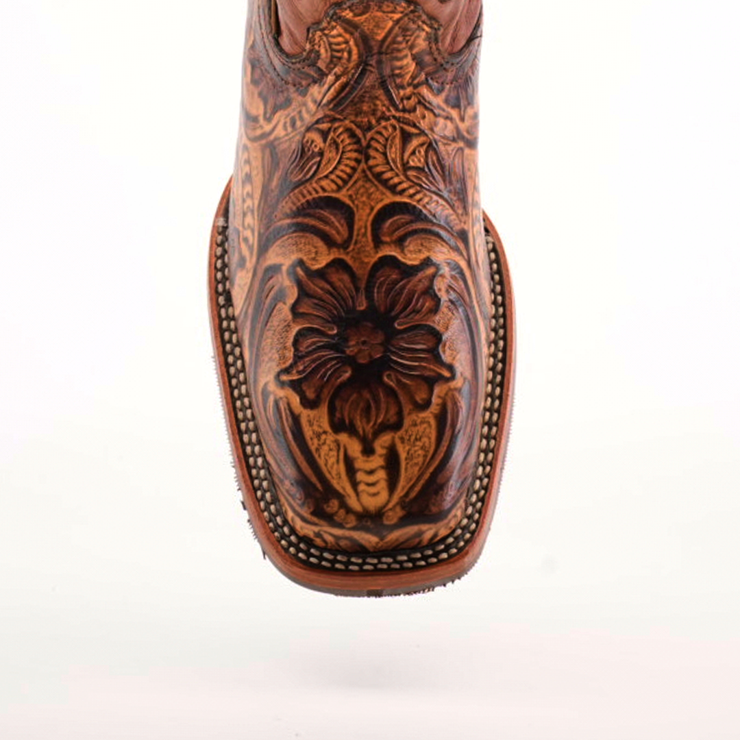 A close-up of the Handtooled Leave Orix boots showcases intricate floral and leaf designs on premium cowhide leather. It features a Rodeo toe with edge stitching and a slip-resistant sole, set against a plain white background.