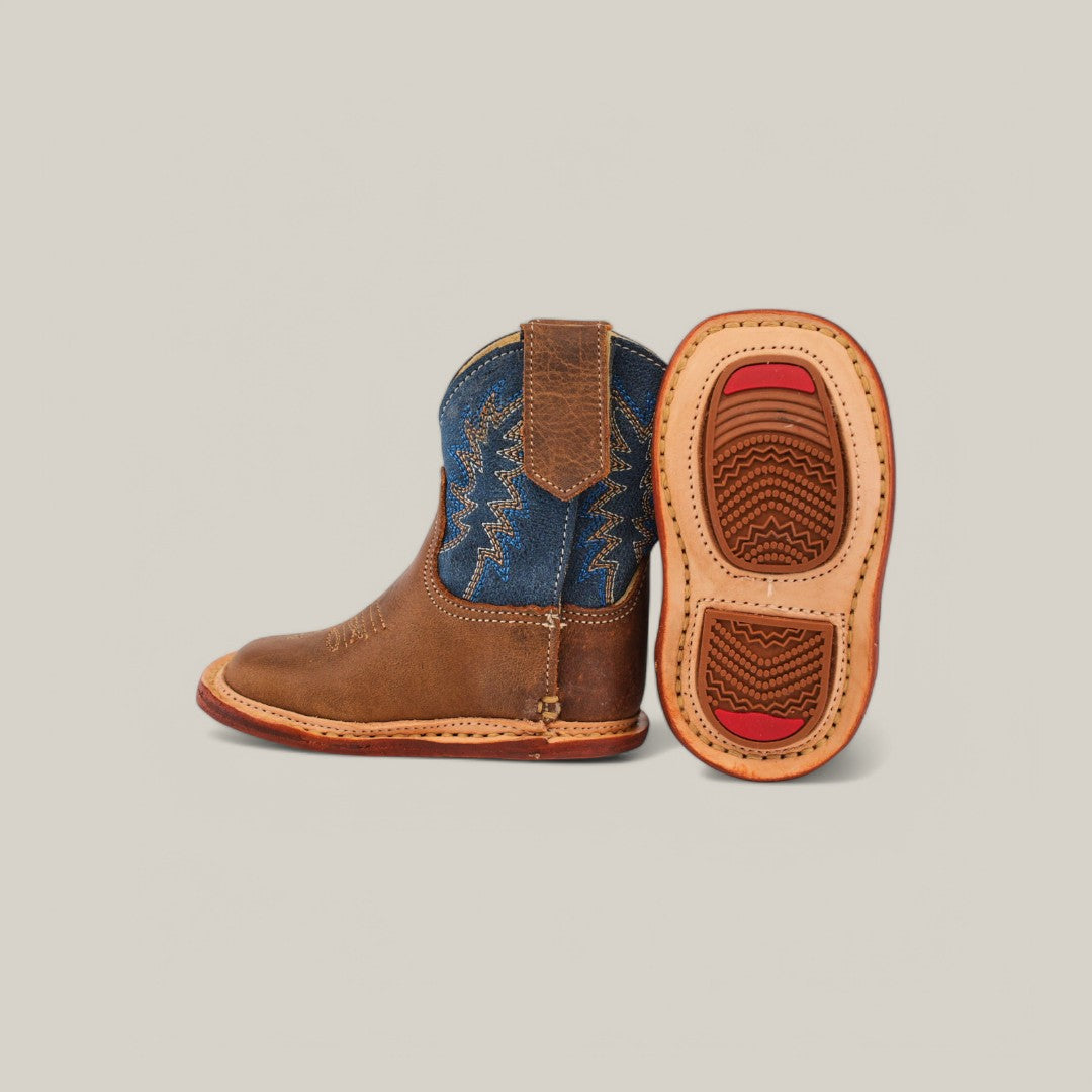 The Max - Honey Blue Shaft childrens cowboy boots feature brown genuine leather and blue denim shafts. One boot stands upright, and the other lies on its side, showing a tan rubber sole with red accents against a plain, light background.