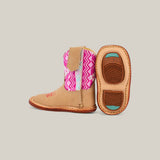 The Holly boots feature a tan leather base with a natural pink Aztec-patterned shaft, square toe design, and textured soles accented in turquoise; one boot stands while the other lies side to show its detail.