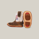 Discover the Scott - Camel USA Shaft - Square Toe Baby Boot, a stylish pair crafted with premium materials. These small cowboy boots have brown leather and white fabric uppers, one featuring an American flag stitched design, and tan soles with red accents.