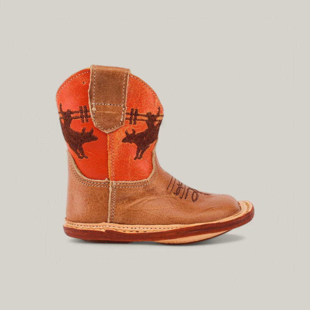 The Dillon - Honey Bull Orange Shaft baby boots feature a small leather design with an orange and light brown shaft, adorned with dark brown cattle and fence embroidery, offering a stylish and comfortable fit for tiny feet.