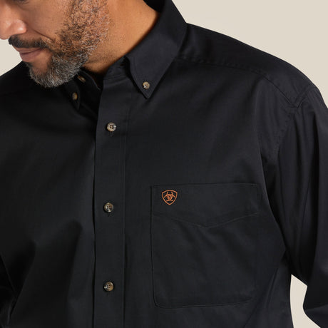 A man in a Solid Twill Classic Fit Shirt Black (Product Code: 10000502), featuring embroidered chest pocket details, stands against a neutral background. His face with a well-groomed beard is partially visible.