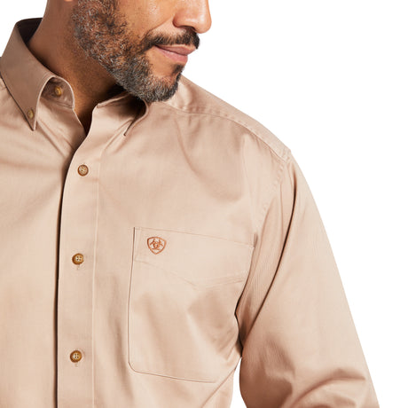 A man models the Kaki Solid Twill Classic Fit Shirt (10000505), featuring elegant embroidery on the chest pocket. The premium cotton twill fabric enhances its refined design and texture, with his face partially visible in profile.