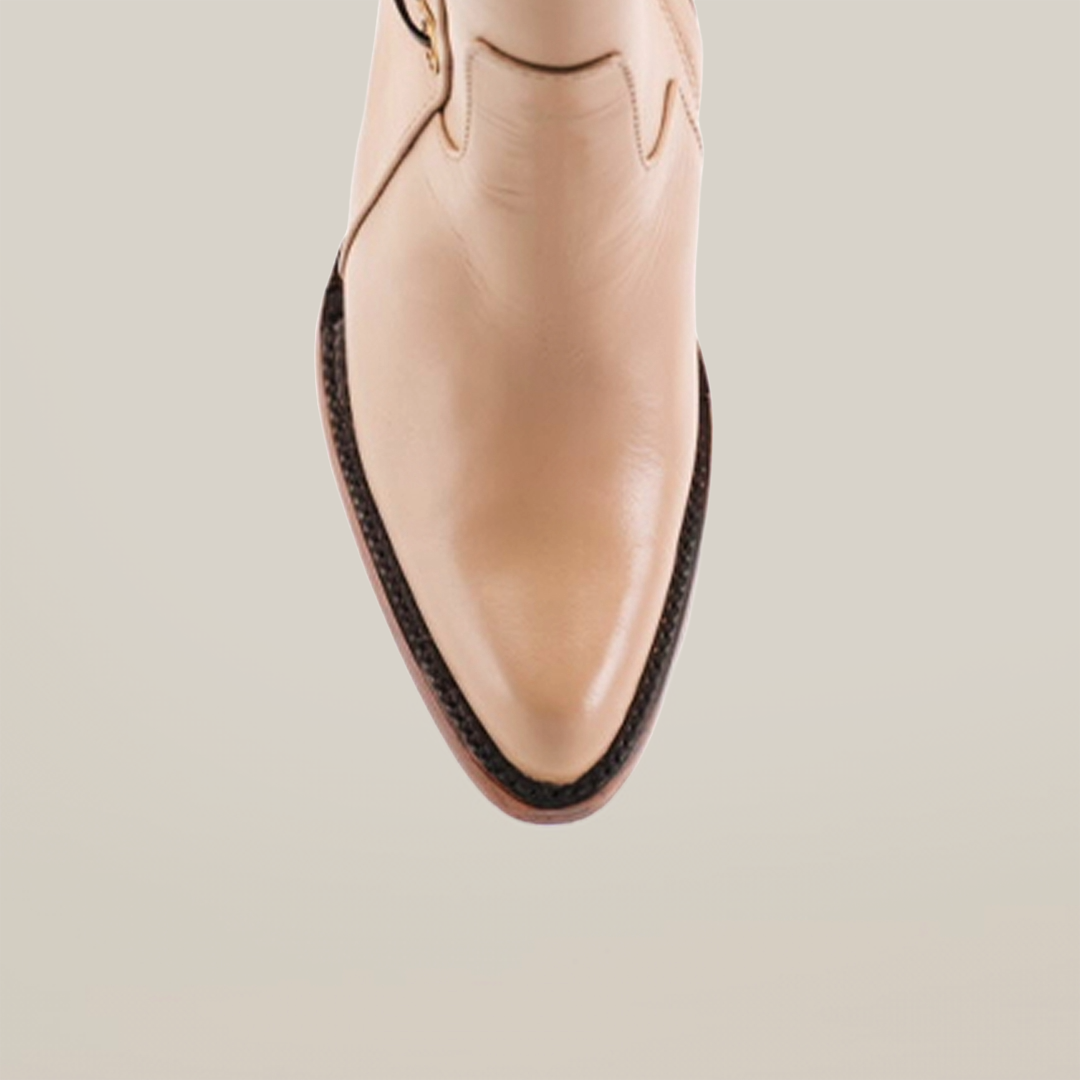 This close-up highlights the Francia Rings Bootie Cream - J Toe from our Platinum Collection. Made with premium leather, it features a pointed toe, dark brown trim, and a polished finish on a pristine white background.