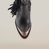 A top view of the Dallas Fringe Bootie Black - J Toe reveals luxury craftsmanship with premium leather, ornate embroidery, tassels, a pointed toe with metallic detailing, and a wooden sole.