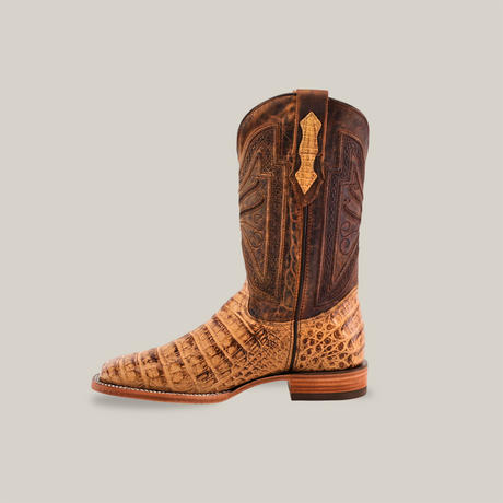 The Exotic Caiman Belly - Antique boot features tan and brown tones with intricate stitching, a caiman belly texture on the lower part, a leather sole, and a square toe. Perfect for cowboy fashion enthusiasts.