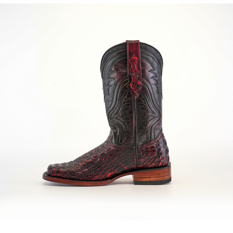 The Exotic Caiman Hornback - Black Cherry - Rodeo Toe is a single leather cowboy boot with intricate black and dark red detailing, ornate stitching, and a wooden heel that embodies the meeting of craftsmanship and tradition, set against a plain white background.