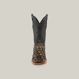 Front view of the Exotic Piraruco Fish - Rustic Antique Square Toe boot featuring intricate black stitching on the shaft and brown textured leather on the foot, set against a plain beige background.