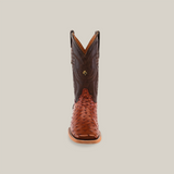 Front view of the Exotic Full Quilt Ostrich boot in Brandy, showcasing a brown ostrich leather foot and darker upper shaft with intricate stitching. The boot reflects the cowboy lifestyle with its square toe and textured pattern against a plain beige backdrop.