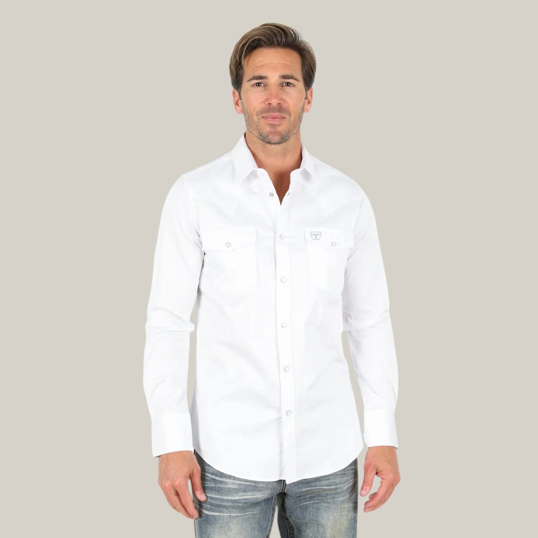 A person in a Men’s Single Pocket Logo Modern Fit Stretch Dress Shirt - White - CTL9259 and jeans. The breathable shirt has a chest logo. The background is plain light gray.