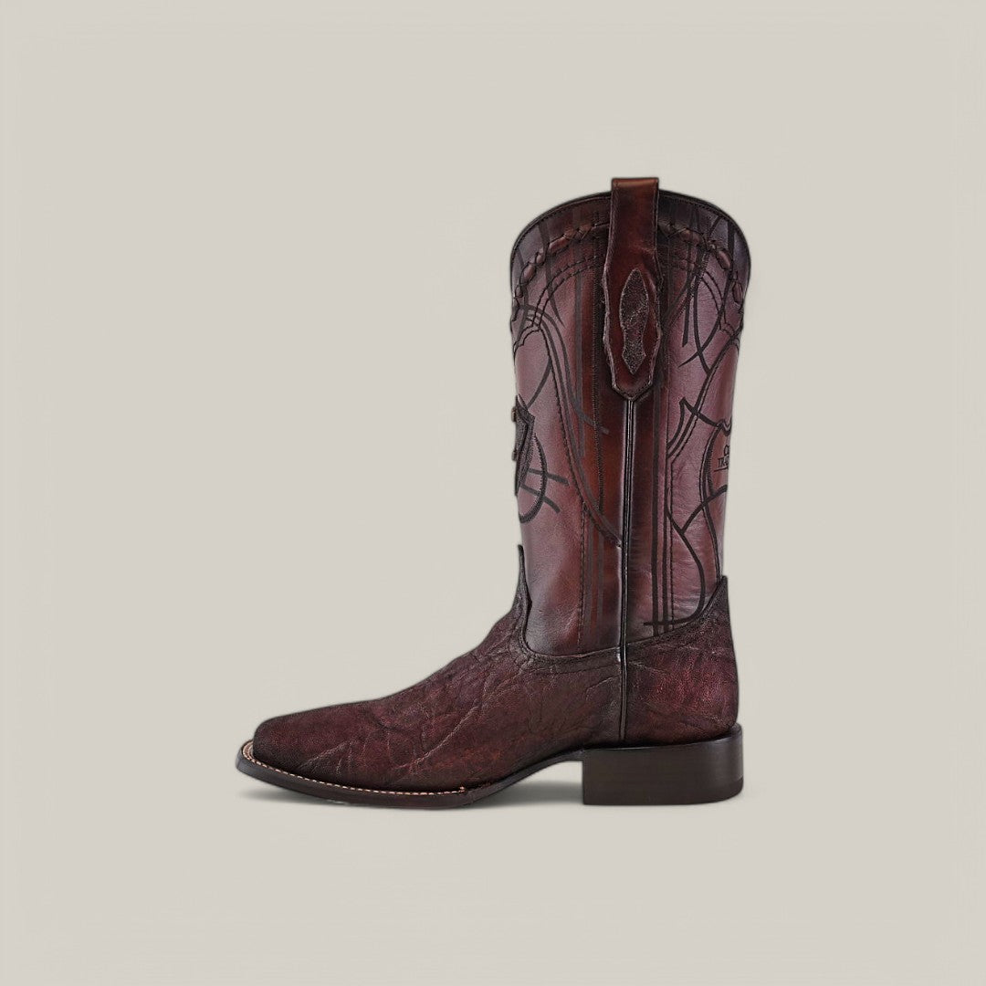 The Brown Elephant Laser & Embroidery - Square Toe - CU848 boot showcases a unique design with intricate stitching and embroidered accents on the shaft, crafted from elephant leather, featuring a square toe and low heel against a plain off-white background.